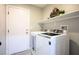 A fully-equipped laundry room with shelving and a modern washer and dryer at 3334 Flying Colt Ct, North Las Vegas, NV 89032