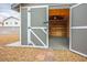 The shed has double doors that open to reveal shelving inside for organized storage at 3334 Flying Colt Ct, North Las Vegas, NV 89032