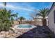 Backyard pool surrounded by lush greenery, desert landscaping and rocks at 3640 Chateau Meadow St, Las Vegas, NV 89129