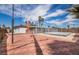 Brick backyard patio with fencing and a distant covered pool at 4409 Cinderella Ln, Las Vegas, NV 89102