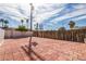 Brick backyard patio with fencing and a distant palm tree at 4409 Cinderella Ln, Las Vegas, NV 89102