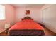 An interior bedroom area featuring hard wood floors, a window, and a bed with orange comforter at 4409 Cinderella Ln, Las Vegas, NV 89102