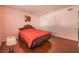 An interior bedroom area featuring hard wood floors, a window, and a bed with orange comforter at 4409 Cinderella Ln, Las Vegas, NV 89102