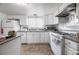 Well-lit kitchen featuring tile floors, white cabinetry, updated appliances, and granite countertops at 4409 Cinderella Ln, Las Vegas, NV 89102