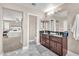 Main bathroom showcasing double sink vanity, walk-in glass shower, and a view to the main bedroom at 4822 Jade Ridge St, North Las Vegas, NV 89081