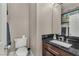 Well-lit half bathroom features a dark countertop and a decorative mirror at 4822 Jade Ridge St, North Las Vegas, NV 89081