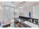 Modern bathroom with a sleek vanity, large mirror, and luxurious marble-tiled shower with glass enclosure at 4822 Jade Ridge St, North Las Vegas, NV 89081