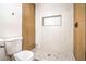 Modern bathroom with tiled shower, built-in niche, and wood accents at 4954 Palmyra Ave, Las Vegas, NV 89146