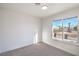 Bright bedroom with fresh neutral paint, carpet, and view of the neighborhood at 4954 Palmyra Ave, Las Vegas, NV 89146