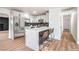 Modern kitchen features a quartz island, stainless steel appliances, black backsplash, and white cabinets at 4954 Palmyra Ave, Las Vegas, NV 89146