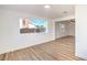 Bright living room featuring wood-style flooring, neutral paint, and large window with backyard view at 4954 Palmyra Ave, Las Vegas, NV 89146