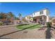 Home's backyard with a putting green, patio seating area, and lush desert landscaping at 511 Via Ripagrande Ave, Henderson, NV 89011