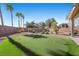 Backyard featuring a putting green, patio area, and mature landscaping at 511 Via Ripagrande Ave, Henderson, NV 89011