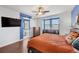 Stylish bedroom with barn-style bathroom door, modern decor, a mounted TV and hardwood floors at 511 Via Ripagrande Ave, Henderson, NV 89011