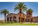 A grand entrance with stone accents, lush landscaping, and a circular driveway at 511 Via Ripagrande Ave, Henderson, NV 89011