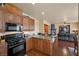 Modern kitchen with stainless steel appliances and wooden cabinetry open to the living area at 511 Via Ripagrande Ave, Henderson, NV 89011