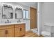 Bright bathroom featuring double sinks, modern mirrors, wood vanity and a glass-enclosed shower at 528 Sheffield Dr, Henderson, NV 89014