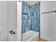 Close-up of an updated shower features a blue tiled wall, a shower niche, and a tub at 528 Sheffield Dr, Henderson, NV 89014