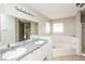 Bathroom featuring double sinks, granite countertops, and a large soaking tub at 557 Liverpool Ave, Henderson, NV 89011