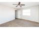 View of a carpeted bedroom featuring neutral walls, a ceiling fan and a door at 557 Liverpool Ave, Henderson, NV 89011