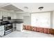 Kitchen with stainless steel appliances, white cabinets, and granite countertops, partially renovated at 557 Liverpool Ave, Henderson, NV 89011