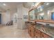 Primary bathroom with a granite countertop, decorative mirror, and natural light at 6 Fire Rock Ct, Las Vegas, NV 89141