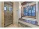 Elegant bathroom featuring granite counters, a soaking tub, and a frameless glass shower at 6 Fire Rock Ct, Las Vegas, NV 89141