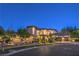 Well-lit, two-story stucco home featuring stone accents, arched windows, and lush, manicured landscaping at 6 Fire Rock Ct, Las Vegas, NV 89141