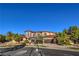 Elegant two-story home featuring a stone facade, arched windows, tile roof, and lush landscaping at 6 Fire Rock Ct, Las Vegas, NV 89141