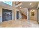 Spacious foyer with travertine flooring, double doors, and a curved staircase featuring decorative ironwork at 6 Fire Rock Ct, Las Vegas, NV 89141