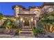 Grand entry featuring stone accents, a gated courtyard, and professional landscape lighting at 6 Fire Rock Ct, Las Vegas, NV 89141