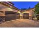 Attached garage with space for three cars, stone trim, and overhead lighting at 6 Fire Rock Ct, Las Vegas, NV 89141