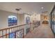 Bright hallway with wrought-iron railing, chandeliers, and large arched windows providing abundant natural light at 6 Fire Rock Ct, Las Vegas, NV 89141