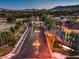 Street view of guard gated entrance leading to tree-lined street with custom homes at 6 Fire Rock Ct, Las Vegas, NV 89141