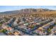 Expansive aerial view of a neighborhood featuring neatly planned streets and homes with stunning mountain backdrop at 6944 Puetollano Dr, North Las Vegas, NV 89084