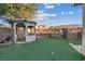 Backyard with green grass and a large gazebo and a tile roof at 6944 Puetollano Dr, North Las Vegas, NV 89084