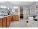 A spacious bathroom featuring double sinks, a walk-in shower, and a modern soaking tub with natural light and tile floors at 6944 Puetollano Dr, North Las Vegas, NV 89084