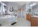 A modern bathroom boasts a large soaking tub with sleek fixtures, patterned tile backsplash, and bright natural light at 6944 Puetollano Dr, North Las Vegas, NV 89084