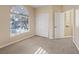 Light-filled bedroom with an arched window, plush carpeting, and closet at 6944 Puetollano Dr, North Las Vegas, NV 89084