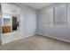 Bedroom with carpet, a large window with blinds, and en-suite bathroom at 6944 Puetollano Dr, North Las Vegas, NV 89084