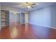 Spacious bedroom with mirrored closet doors, ceiling fan, and wood-look flooring at 725 N Royal Crest Cir # 213, Las Vegas, NV 89169