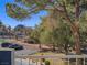 Scenic view from balcony overlooking lush greenery, a gazebo, and parking, with city views in the distance at 725 N Royal Crest Cir # 213, Las Vegas, NV 89169