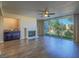 Open living area with fireplace, bar area, ceiling fan and large glass doors to balcony at 725 N Royal Crest Cir # 213, Las Vegas, NV 89169