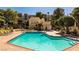 Community pool with sun loungers surrounded by lush green landscaping at 725 N Royal Crest Cir # 213, Las Vegas, NV 89169