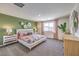 This bedroom features a decorative accent wall, gray carpet, and a queen size bed with decorative pillows and bedspread at 804 Ruby Sedona Ave # Lot 152, North Las Vegas, NV 89081