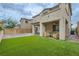 Spacious backyard featuring lush green grass, a covered patio, and an outdoor kitchen area at 8125 Skye Vineyard Dr, Las Vegas, NV 89166