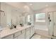 Well-lit bathroom with a double sink vanity, soaking tub, and glass-enclosed shower at 8125 Skye Vineyard Dr, Las Vegas, NV 89166