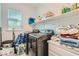 Efficient laundry room featuring modern washer and dryer units, plus storage shelving at 8125 Skye Vineyard Dr, Las Vegas, NV 89166