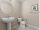 Modern half bath with a pedestal sink, toilet, and decorative artwork at 8255 Las Vegas Blvd # 610, Las Vegas, NV 89123