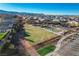 Aerial view of community park featuring a walking path, basketball court, playground, and open green space at 9007 Antora Summit St, Las Vegas, NV 89166